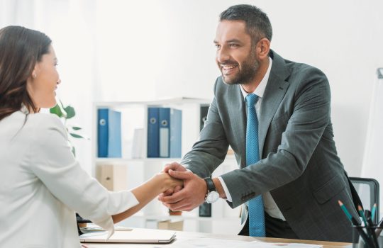 handsome-advisor-in-suit-shaking-hands-with-investor-at-workplace.jpg